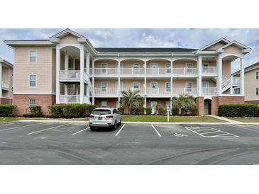 Three-story condo building with white balconies and a parking lot in front at 3979 Forsythia Ct. # 203, Myrtle Beach, SC 29588