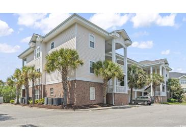 Exterior view of the condo featuring palm trees and manicured landscaping at 4803 Bovardia Pl. # 104, Myrtle Beach, SC 29577