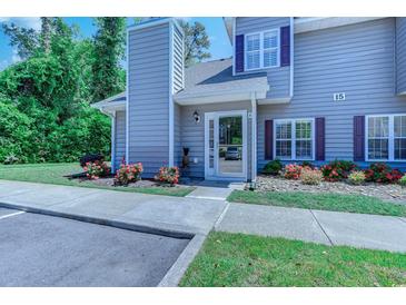 Charming two-story townhome with gray siding, colorful flower beds, and an inviting front entrance at 503 20Th Ave. N # 15-A, North Myrtle Beach, SC 29582