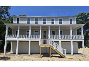Stunning elevated home with a charming porch and staircase leading to the front door at 507 Hillside Dr. N, North Myrtle Beach, SC 29582