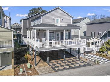 Inviting elevated home with covered parking, spacious deck, and gray siding, perfect for coastal living at 6001-T36 South Kings Hwy., Myrtle Beach, SC 29575