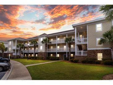 Three-story condo complex with palm trees and a beautiful sunset at 6253 Catalina Dr. # 1533, North Myrtle Beach, SC 29582