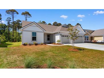 Charming one-story home with a well-manicured lawn and a three-car garage at 1421 Crested Iris Way, North Myrtle Beach, SC 29582