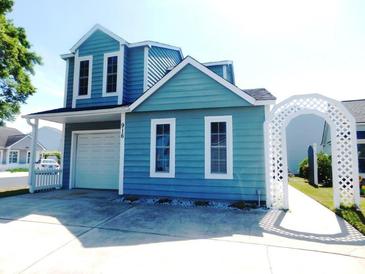 Charming two-story blue home with a garage, white picket fence and a delightful arched walkway at 916 Charles St., North Myrtle Beach, SC 29582