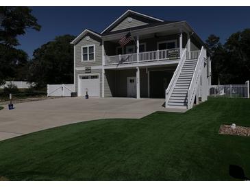 Charming two-story home with a garage, beautiful landscaping, and a welcoming second-story porch at 928 Strand Ave. Strand Ave., North Myrtle Beach, SC 29582