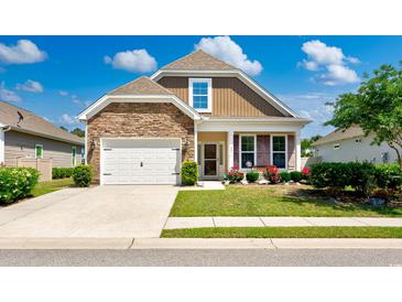 Charming single-Gathering home featuring a stone facade, a well-manicured lawn, and a two-car garage at 962 Witherbee Way, Little River, SC 29566