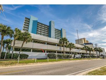 Beautiful resort building with covered parking and tropical palm tree landscaping at 1012 N Waccamaw Dr. # 301, Garden City Beach, SC 29576