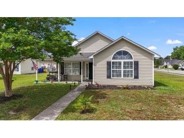 Charming single-story home with a well-manicured lawn, sidewalk, and inviting front porch seating area at 1108 Blue Juniper Ct., Conway, SC 29527