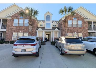 Inviting brick building exterior featuring palm trees, well-manicured grounds, and convenient parking at 119 Brentwood Dr. # D, Murrells Inlet, SC 29576