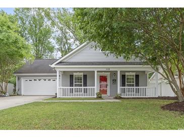 Charming single-story home featuring a welcoming front porch, well-manicured lawn, and an attached garage at 119 Pickerel Blvd., Longs, SC 29568