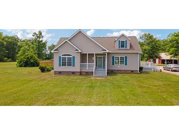 Charming single-Gathering home with a well-manicured lawn, gray siding, a covered front porch, and turquoise shutters at 151 Saddle Dr., Loris, SC 29569