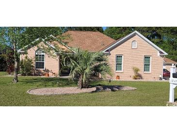 Charming brick home with a well-manicured lawn, a palm tree, and mature trees providing shade at 1717 Perdiz Covey Ct., Myrtle Beach, SC 29588