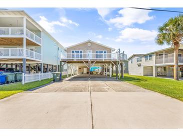 Coastal home with a large driveway and elevated stilt construction, with a deck at 209 25Th Ave. N, North Myrtle Beach, SC 29582