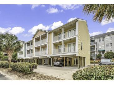 Inviting condo complex with private balconies and covered parking, surrounded by manicured landscaping at 209 Hillside Dr. N # 104, North Myrtle Beach, SC 29582
