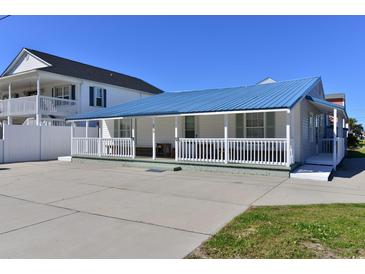 Charming single-story home featuring a blue metal roof, a welcoming front porch, and ample parking space at 219 27Th Ave. N, North Myrtle Beach, SC 29582