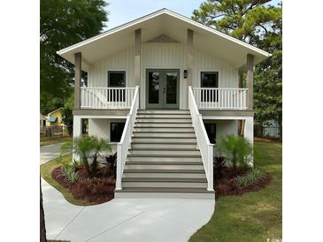 Charming two-story home featuring a lovely stairway, elevated porch, and beautifully landscaped front yard at 326 15Th Ave. S, Surfside Beach, SC 29575