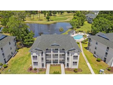 Aerial view of a beautiful condominium complex overlooking a lake, golf course, and swimming pool at 545 White River Dr. # 15 D, Myrtle Beach, SC 29579