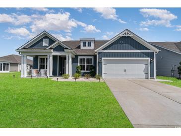 Charming single-Gathering home showcasing a well-maintained lawn and a two-car garage with a covered porch at 567 Hickman St., Myrtle Beach, SC 29575