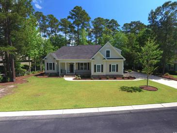 Charming home with a well-manicured lawn, mature trees, and a welcoming front porch at 625 Whispering Pines Ct., Murrells Inlet, SC 29576