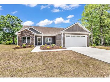 Charming single-story home features a stone facade, attached two-car garage, and well-manicured lawn at 718 Highway 348, Loris, SC 29569