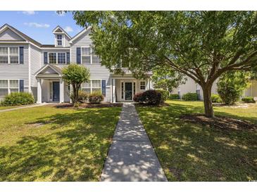 Charming two-story townhome with blue shutters and a well-manicured lawn and walkway at 1127 Harvester Circle # 1127, Myrtle Beach, SC 29579