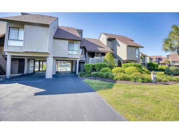 Beautiful exterior view of a multi-level home with a covered parking area and lush landscaping at 124 Spartina Ct. # 30, Pawleys Island, SC 29585
