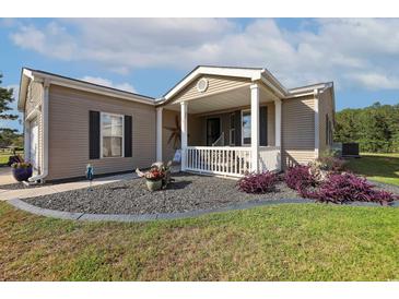 Charming one-story home with a cozy front porch and professionally landscaped yard at 133 Lakeside Crossing Dr., Conway, SC 29526