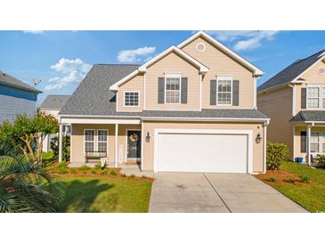 Charming two-story home featuring a manicured lawn, a two-car garage, and welcoming front porch at 1439 Brighton Ave., Myrtle Beach, SC 29588