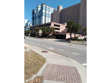 Street view of the hotel with tropical landscaping and garage entrance, highlighting its coastal location at 2207 S Ocean Blvd. # 1407, Myrtle Beach, SC 29577