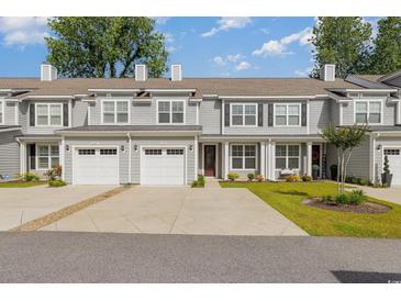 Charming townhouse featuring a manicured lawn, two-car garage, and classic architectural details at 2409 Thoroughfare Dr. # 2409, North Myrtle Beach, SC 29582