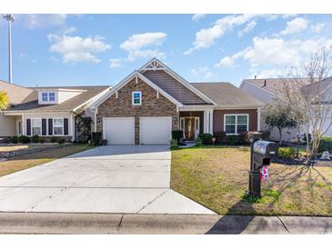 Charming single-Gathering home featuring a stone facade, two-car garage, and manicured lawn at 3672 White Wing Circle, Myrtle Beach, SC 29579