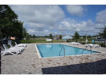 Community pool with lounge chairs, and a clear view of the neighborhood under a blue sky at 430 Lifestyle Court, Surfside Beach, SC 29575