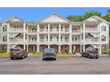 Three-story condo building with white balconies, green shutters, and well-maintained landscaping at 4429 Turtle Ln. # 3A, Little River, SC 29566