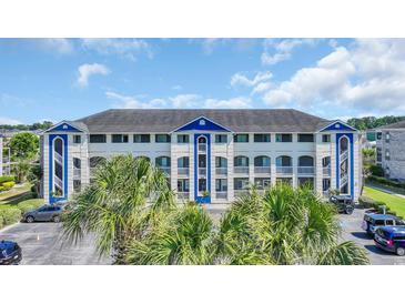 Beautiful condominium complex with blue and white trim accents surrounded by palm trees at 4522 N Plantation Harbour Dr. # E-3, Little River, SC 29566