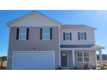 Two story home with a white garage door, neutral siding, black shutters and a porch at 528 Scarlet Sage Dr., Conway, SC 29527