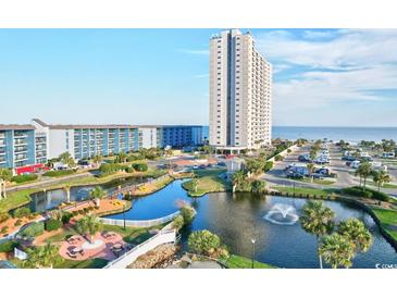 Scenic aerial view of a coastal condominium complex with a beautiful pond and ocean views at 5905 Ocean Blvd. S # 1608, Myrtle Beach, SC 29577