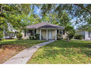 Charming single-story home with a well-maintained lawn, a paved walkway, and mature trees at 6612 Wintergreen Point, Myrtle Beach, SC 29588