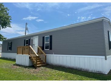 Charming manufactured home with gray siding, black shutters, and a wooden porch with stairs at 1242 Carrie Bell Ln, Myrtle Beach, SC 29577