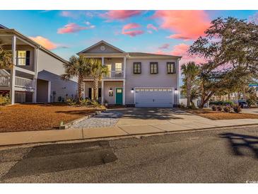 Inviting two-story home with covered porch, palm trees, and a two-car garage at 226 9Th Ave. S, North Myrtle Beach, SC 29582