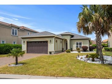Charming single-story home featuring a well-manicured lawn, brown two-car garage, and tasteful landscaping at 274 Avenue Of The Palms, Myrtle Beach, SC 29579