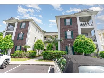 Well-maintained condo building with brick facade, green shutters, and landscaped grounds at 488 River Oaks Dr. # 61F, Myrtle Beach, SC 29579