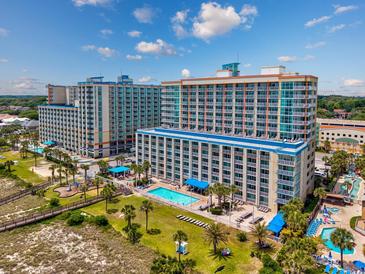 Expansive aerial view of a beachfront resort featuring multiple pools, palm trees, and inviting ocean access at 5300 N Ocean Blvd. # 422, Myrtle Beach, SC 29572