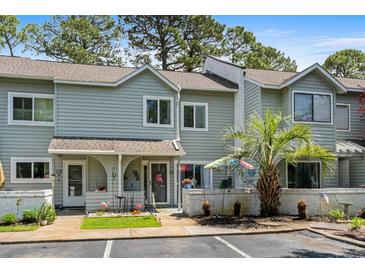 Inviting townhome exterior with a tidy lawn, mature trees, and reserved parking spaces in a desirable neighborhood at 55 Shadow Moss Pl. # 55, North Myrtle Beach, SC 29582