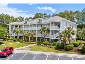 Beautiful three-story condo building with palm trees, landscaping, and private balconies at 6253 Catalina Dr. # 422, North Myrtle Beach, SC 29582