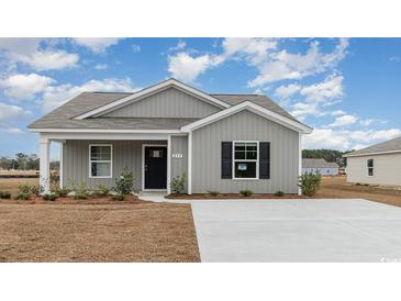 Charming single-story home with gray siding, black shutters, and a well-manicured lawn on a sunny day at 631 Culmen Ct., Myrtle Beach, SC 29588