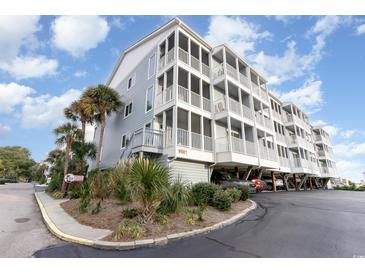Coastal condo building featuring multiple balconies, palm trees, and covered parking at 9581 Shore Dr. # 216, Myrtle Beach, SC 29572