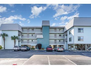 Beautiful exterior of a multi-story condo building with ample parking, blue facade, and balconies at 1011 S Ocean Blvd., Surfside Beach, SC 29575