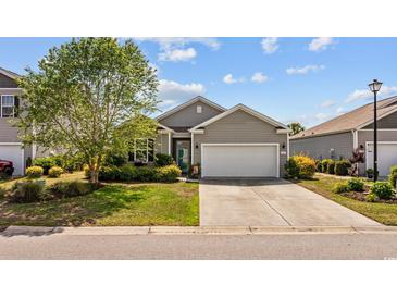 Charming single-story home featuring a well-manicured lawn, gray siding and a two-car garage at 125 Mountain Ash Ln., Myrtle Beach, SC 29579