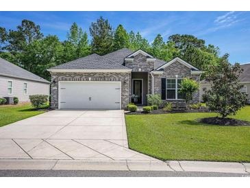 Charming brick home featuring an attached garage and a well-manicured lawn at 1434 Chanson Ct., Little River, SC 29566