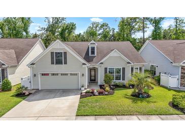 Charming home with a well-manicured lawn, attached garage, and beautiful landscaping at 1681 Suncrest Dr., Myrtle Beach, SC 29577